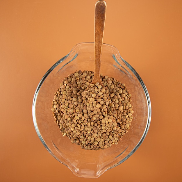 Lentils in a bowl and wooden spoon