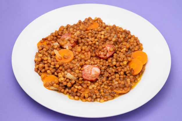 Foto lenticchie con chorizo e carota su piatto bianco ricetta tipica spagnola