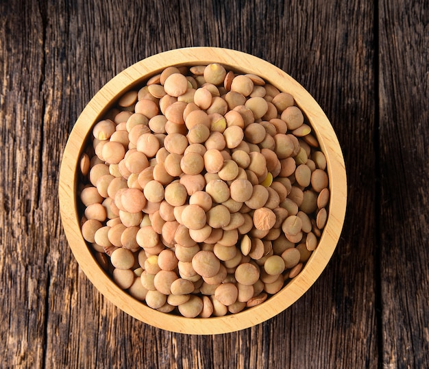 Lentils in wood bowl on wood table