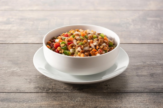 Lentilsalade met peppersonion en wortel in een schaal op een houten tafel