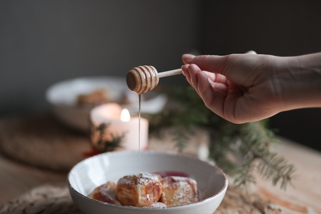 Foto lepel gietende honing op plaat. bord met fluitje van een cent. heerlijke honingcake met decoratie. nieuw ontwerp maken voor het dessert.