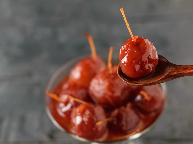 Lepel met Apple-jam op de achtergrond van een vaas met jam van gehele appelen.