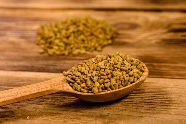 Lepel met fenegriekzaden op rustieke houten tafel