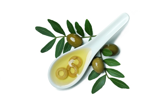 Lepel met olijfolie, olijven en takjes op wit wordt geïsoleerd