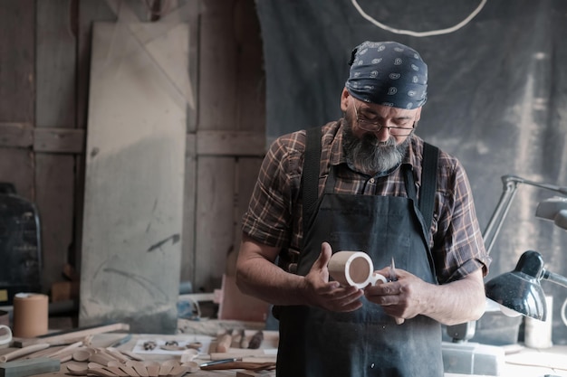 Lepelmeester in zijn atelier met houten producten en gereedschappen. Hoge kwaliteit foto