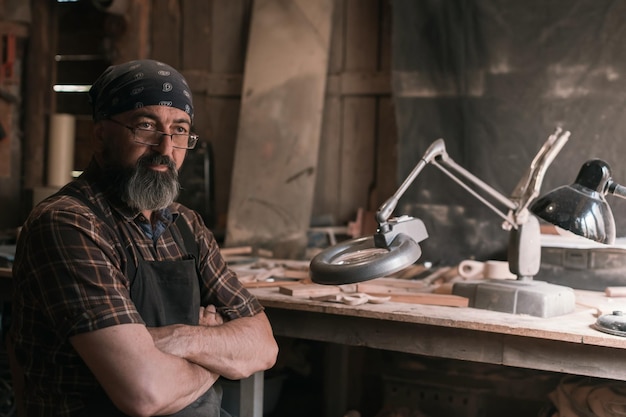 Lepelmeester in zijn atelier met houten producten en gereedschappen. Hoge kwaliteit foto