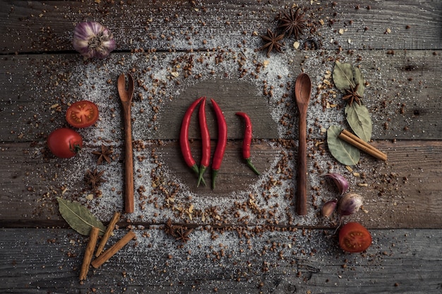 Foto lepels met kruiden op een houten tafel met kruiden erop verspreid