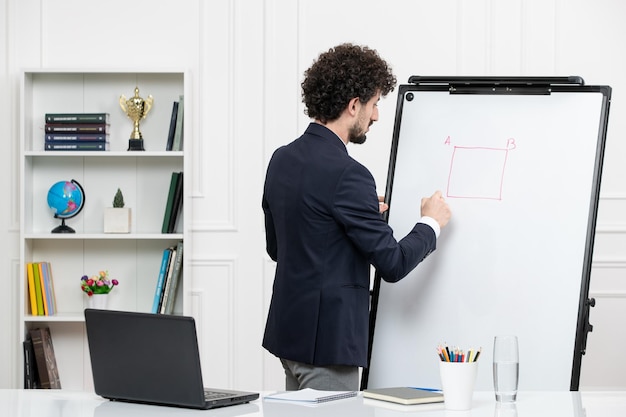 Leraar brunette instructeur met computer in pak en whiteboard in klaslokaal tekenvierkant