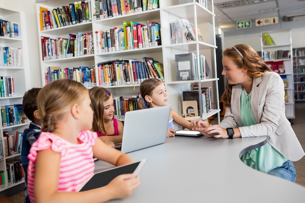 Leraar die computer met leerlingen met behulp van