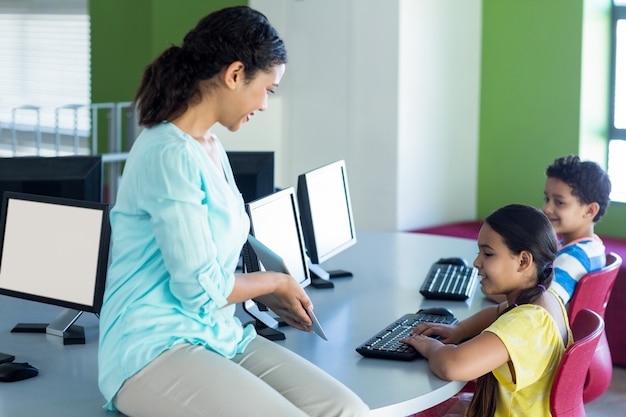 Leraar die digitale tablet tonen aan kinderen