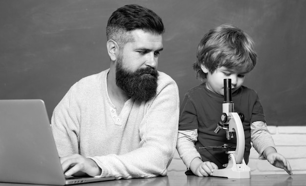 Leraar die leerlingen helpt die op bureaus in klaslokaal studeren jonge jongen die zijn schoolthuiswerk doet met zijn f