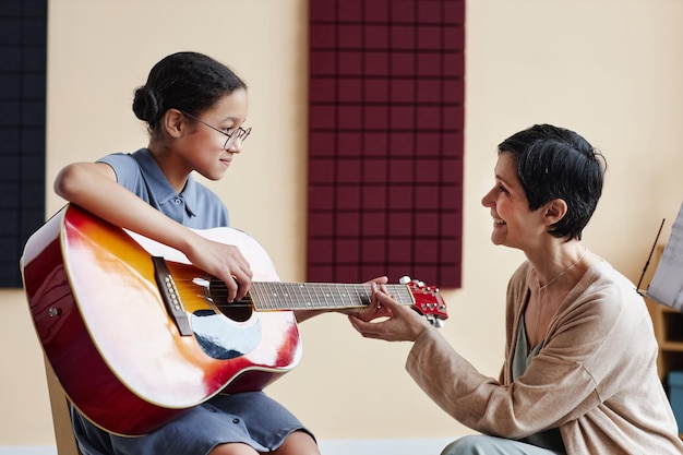 Leraar die student leert gitaar te spelen