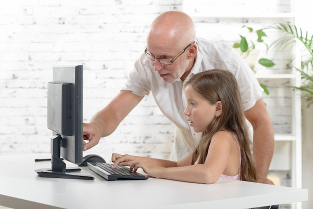 Leraar en een schoolmeisje met een computer