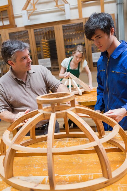 Leraar en een student in een houtbewerking klasse werken aan een frame