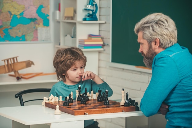 Leraar en kind Spelletjes en activiteiten voor kinderen Leraar en kind Man leraar schaken met peuter kind Vader en zoon