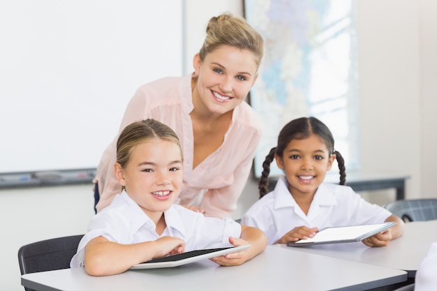 Leraar en kinderen met behulp van digitale tablet