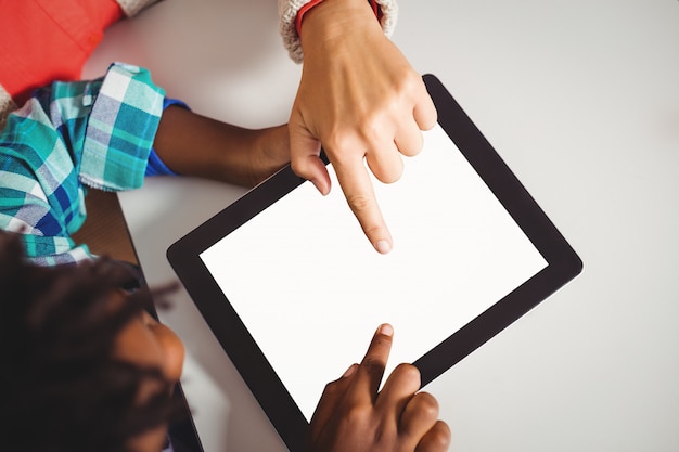 Leraar en leerling die een tablet gebruiken