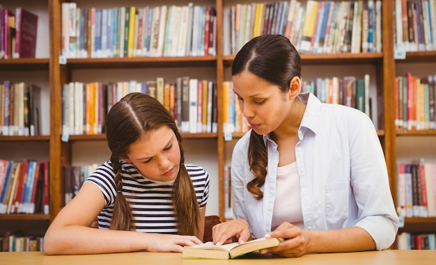 Leraar en meisjeslezingsboek in bibliotheek