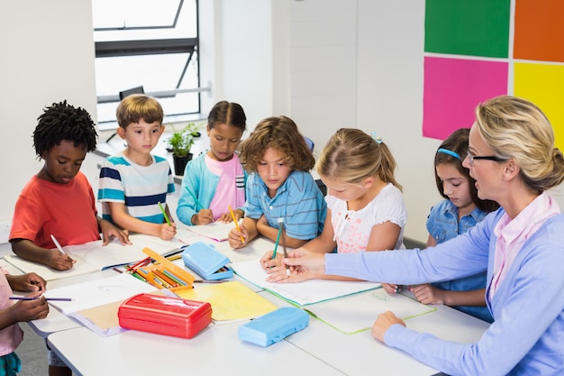 Leraar helpt kinderen met hun huiswerk in de klas