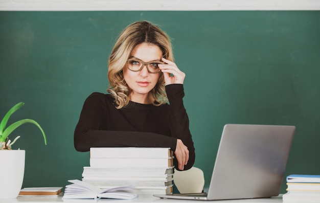 Leraar in de klas aan de universiteit of hogeschool vrouwelijke student aan boord met computer laptop les se