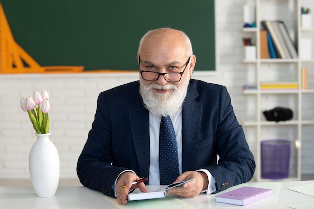 Leraar in de klas in de buurt van het bord geeft een les Professor aan de universiteit is giv