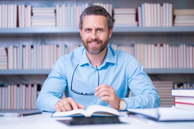 Leraar in kennis en onderwijs in de klas met knappe leraar leraar met boek in de klas