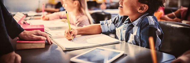 Foto leraar interactie met schooljongen in de klas