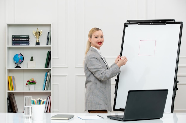 Leraar jonge schattige instructeur in pak in klas met laptop en whiteboard tekenvierkant