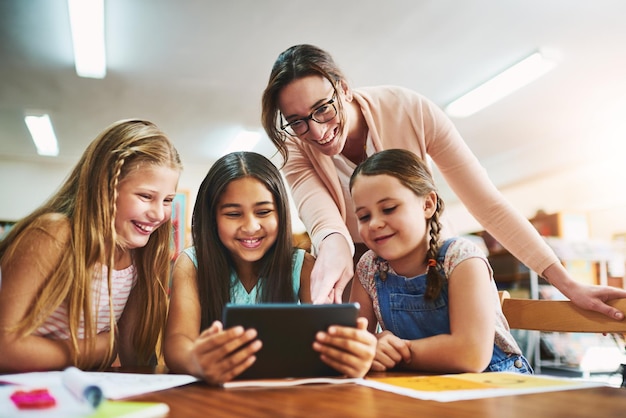 Leraar kinderen en digitaal met tablet voor onderwijs e-learning en wiskunde spel voor getallen oplossen vaardigheid School opvoeder en studenten in de basisschool voor kennis vermenigvuldiging en studeren app