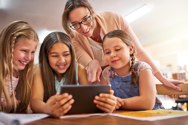 Leraar kinderen en ondersteuning met tablet voor onderwijs e-learning en wiskunde spel voor getallen oplossen vaardigheid School opvoeder en studenten in de basisschool voor kennis vermenigvuldiging en studeren app