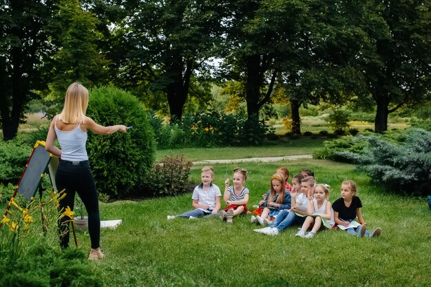 Leraar leert een klas kinderen in een openluchtpark
