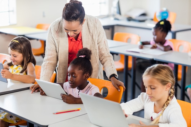 Leraar les geven aan haar studenten met laptops