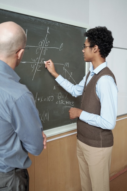 Leraar luisteren naar uitleg van student door blackboard