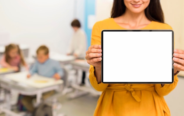 Foto leraar met een tablet in de klas