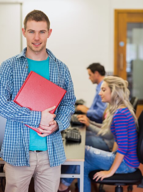 Leraar met jonge studenten die computers in computerzaal gebruiken