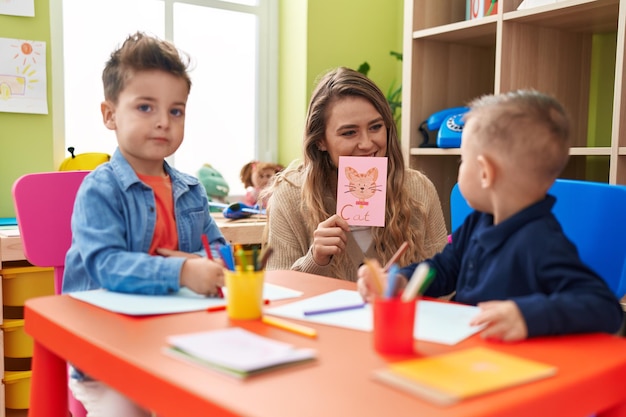 Leraar met jongens die op tafel zitten en taalles hebben op de kleuterschool