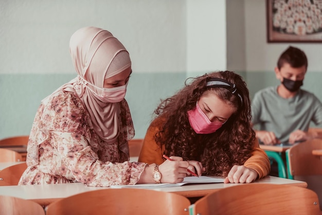 Leraar met medisch masker wijzend met een vinger in de buurt van verveeld schoolmeisje Nieuw normaal onderwijs tijdens de Covid19-pandemie Selectieve focus Foto van hoge kwaliteit