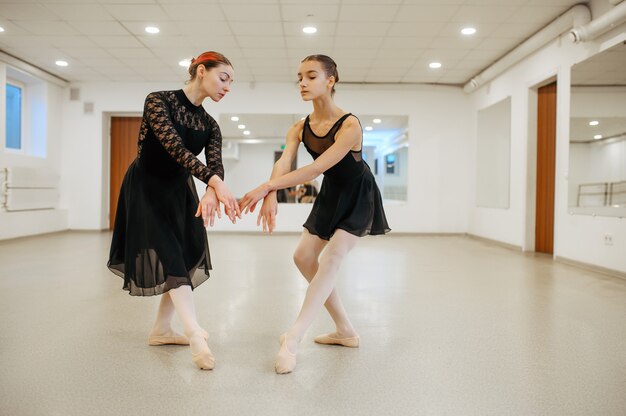 Leraar repeteert met jonge ballerina in de klas. Balletschool, danseressen op choreografieles, meisjes die grace-dans beoefenen