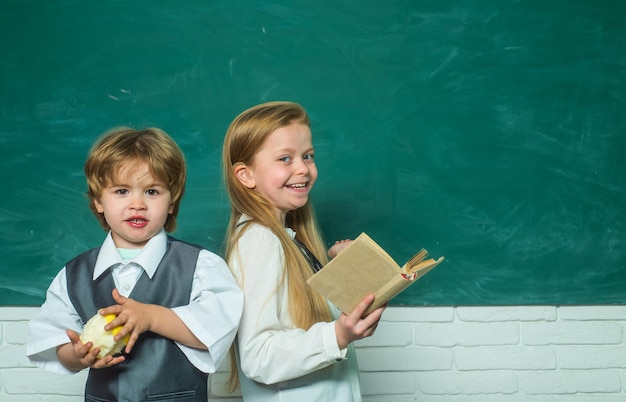 Leraar schoolmeisje schooljongen helpen met les basisschool kinderen in de klas op school educa