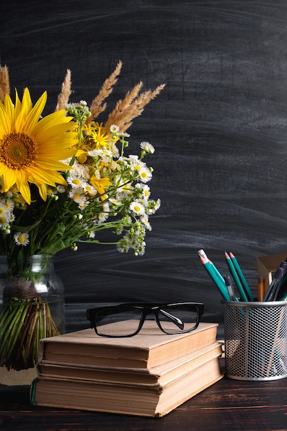 Foto leraren dag. zwart schoolbord en verse wilde bloemen in vaas