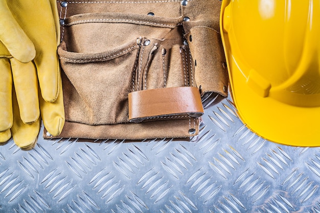 Leren bouwriem beschermende handschoenen helm op gegroefde metalen plaat constructieconcept