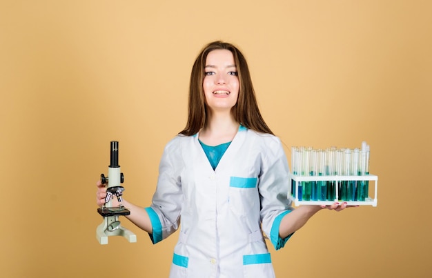 Leren chemie in school laboratorium gelukkige vrouw wetenschapper in lab goede resultaten vrouw arts met reageerbuis en Microscoop onderzoek meisje student doen wetenschappelijk experiment met Microscoop in lab