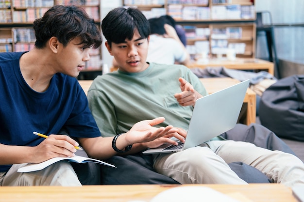 Leren, onderwijs en schoolconcept. Jonge vrouw en man die voor een test of een examen studeren. Bijlesboeken met vrienden. Jonge studentencampus helpt vriend bij te praten en te leren.