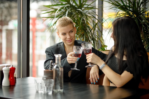 Lesbian couple on a date in a restaurant drinking wine