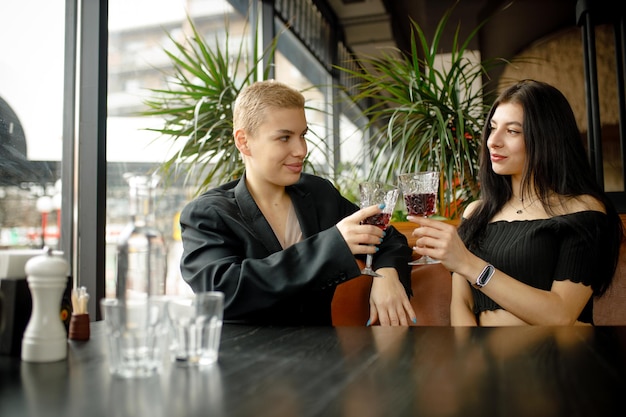 Lesbian couple on a date in a restaurant drinking wine