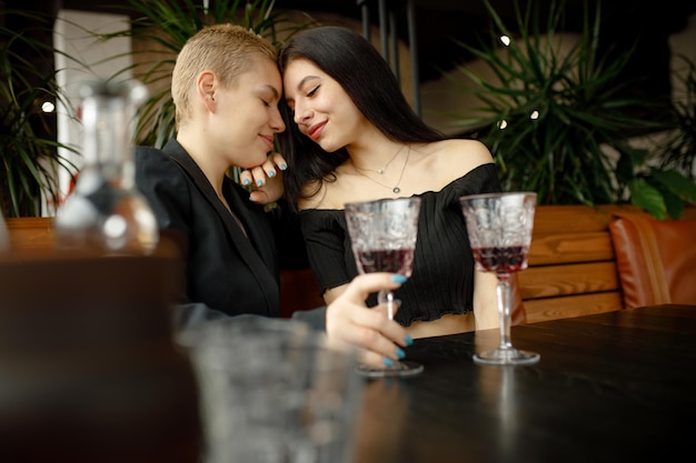 Lesbian couple on a date in a restaurant drinking wine