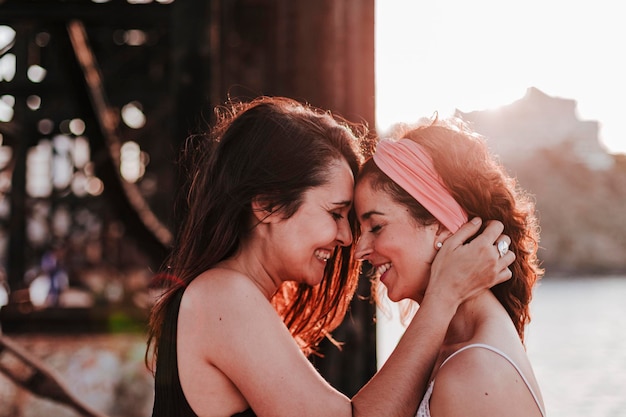 Photo lesbian couple embracing by sea