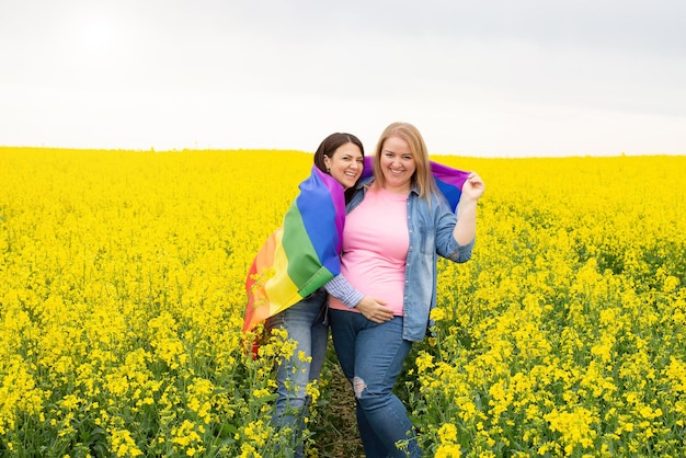 La coppia lesbica tiene la bandiera lgbt arcobaleno il concetto di sostenere la parità di diritti per le minoranze sessuali