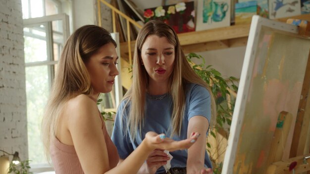 Photo lesbian couple looking at painting