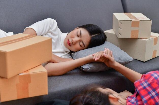 Lesbian couple sleeping by boxes at home